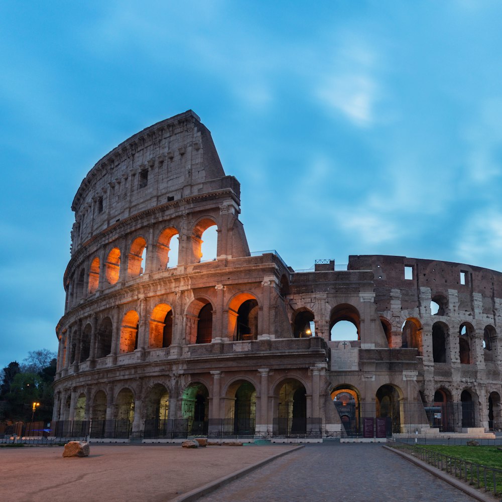 A vast Roman amphitheatre lit at dusk.